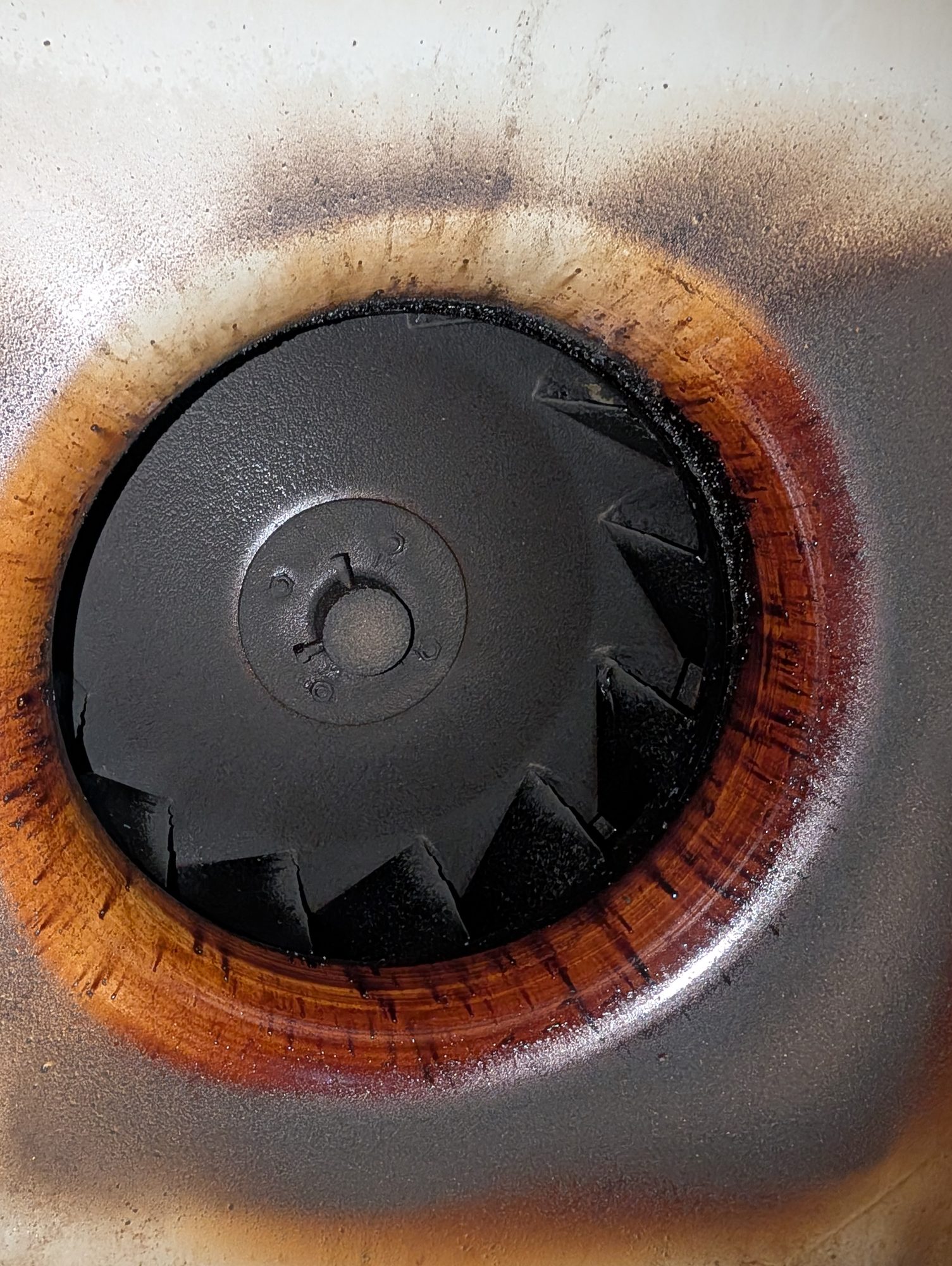 Kitchen exhaust fan bowl coated in baked-on grease before cleaning