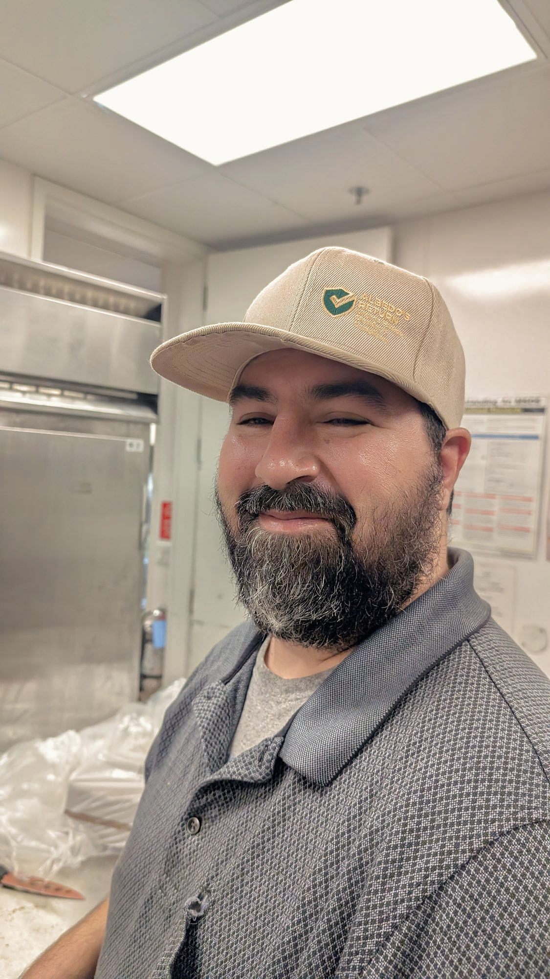 Man in an Albedo's Return cap inside a commercial kitchen
