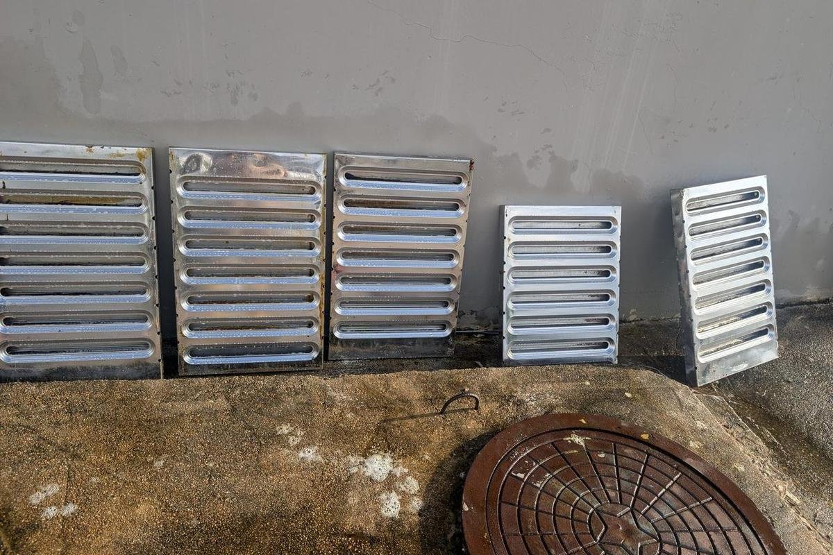 Cleaned baffle hood filters standing on edge outdoors to drain and dry
